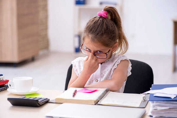 Забавная маленькая девочка работает в офисе