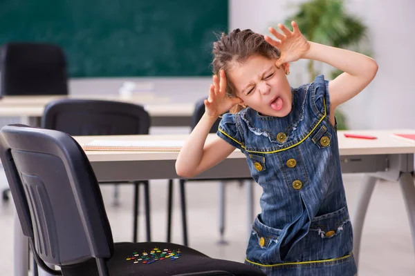 Brincadeira escola secundária com thumbtacks afiados na cadeira — Fotografia de Stock