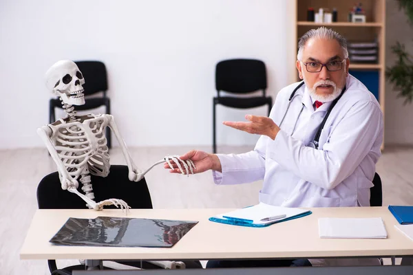 Gammal manlig läkare och skelettpatient på kliniken — Stockfoto