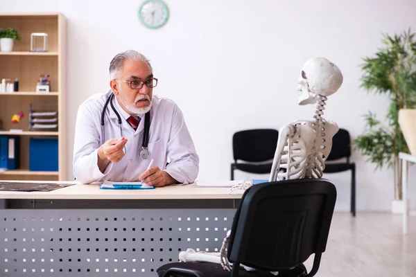 Gammal manlig läkare och skelettpatient på kliniken — Stockfoto