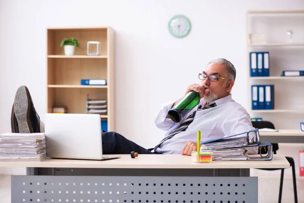 Un vieil employé boit de l'alcool au bureau — Photo