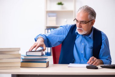 Kitap yazan yaşlı bir erkek yazar.