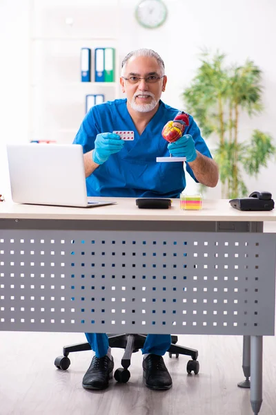 Oude mannelijke arts apotheker werkzaam in de kliniek — Stockfoto