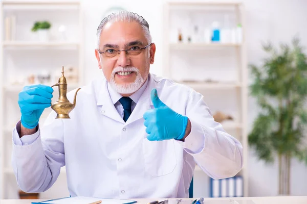 Oude senior archeoloog werkzaam in het lab — Stockfoto