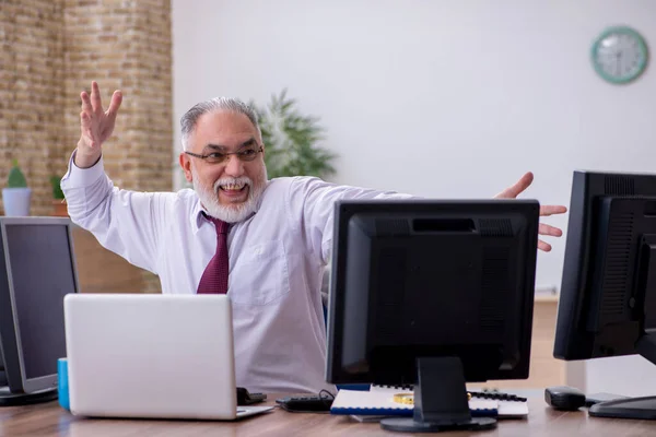Vecchio capo maschio seduto sul desktop in ufficio — Foto Stock