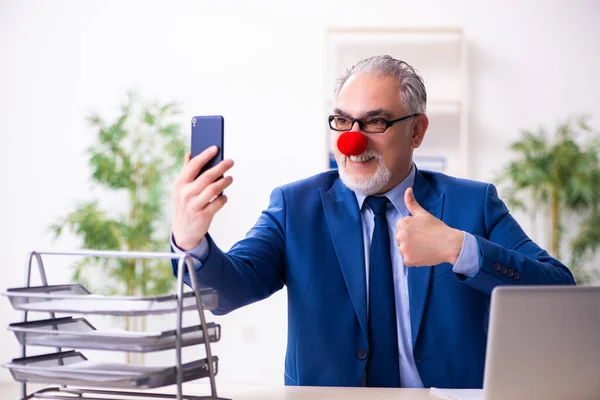 Vieil homme d'affaires clown travaillant dans le bureau — Photo