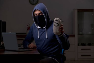 Erkek bilgisayar korsanı, güvenlik duvarını geç saatlerde hackliyor.