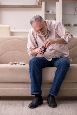 Yaşlı hasta adam evde acı çekiyor.