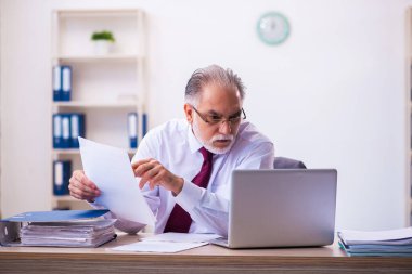 Ofiste çalışan yaşlı bir erkek.