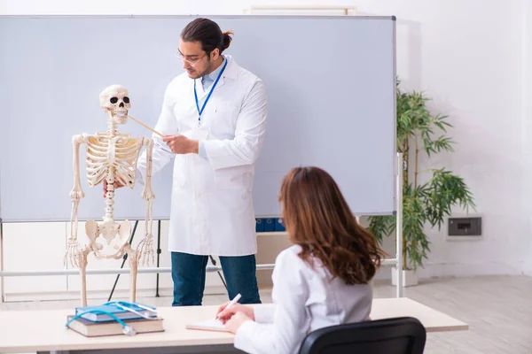 Jovem professor médico, esqueleto e estudante do sexo feminino no cl — Fotografia de Stock