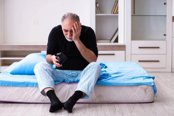 Vecchio a corto di soldi in camera da letto — Foto Stock