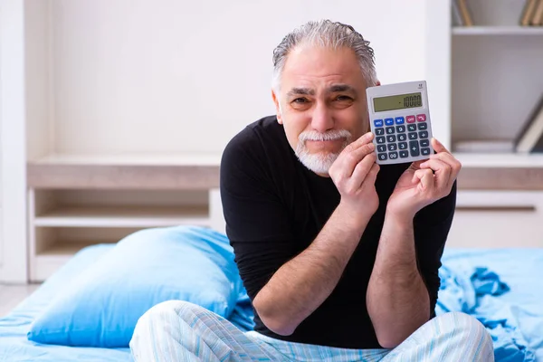 Old man in bankruptcy concept in the bedroom — Stock Photo, Image