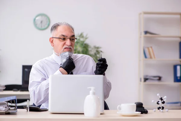 Old male boss employee working during pandemic