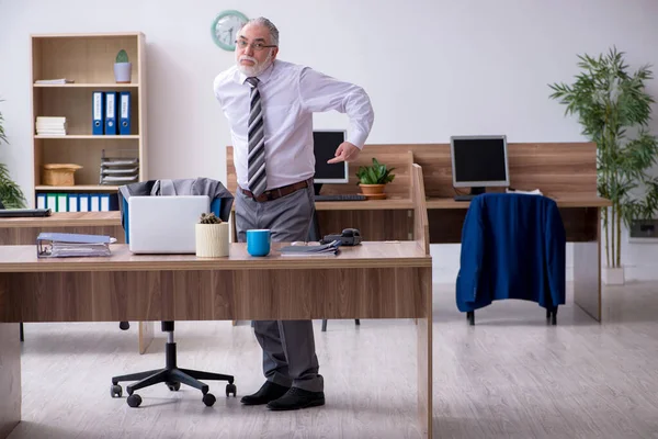 Velho trabalhador masculino que sofre de radiculite no local de trabalho — Fotografia de Stock