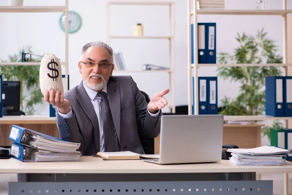 Velho empregado masculino segurando saco de dinheiro no conceito de aposentadoria — Fotografia de Stock