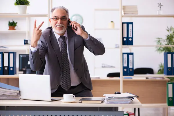 Ancien employé masculin utilisant le téléphone dans le bureau — Photo