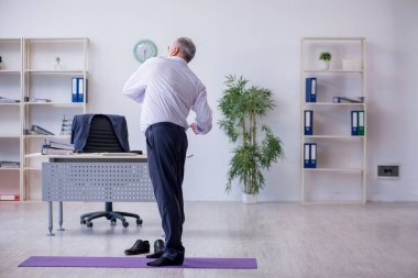 Mola sırasında fiziksel egzersiz yapan yaşlı bir erkek.