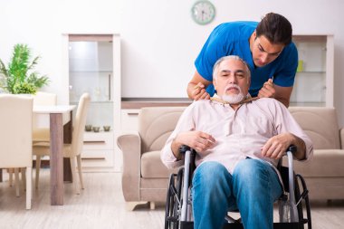 Tekerlekli sandalyedeki yaşlı adam ve genç kötü bakıcı.