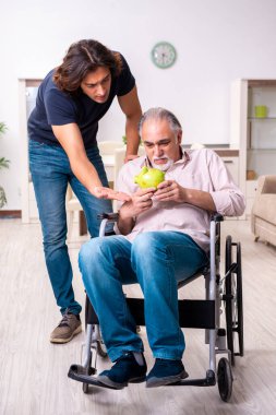 Tekerlekli sandalyedeki yaşlı adam ve genç kötü bakıcı.