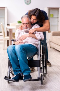 Tekerlekli sandalyedeki yaşlı adam ve genç kötü bakıcı.