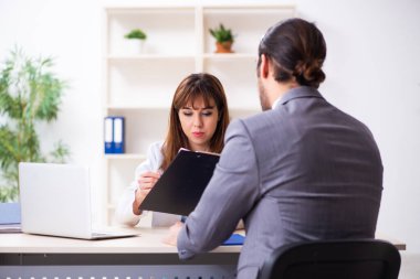 Genç bayan doktor ve hasta iş adamı ofiste.