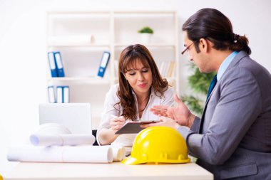 Genç işadamı ve bayan mimar yeni projeyi tartışıyor