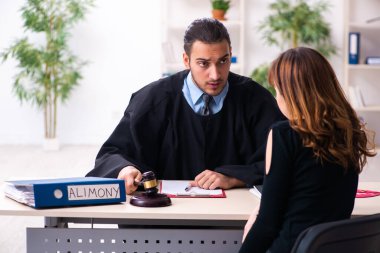 Boşanma konseptinde genç erkek yargıç ve genç kadın.
