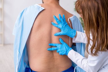 Genç sırtı yaralı bir adam, kadın doktor masörünü ziyaret ediyor.