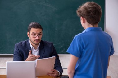 Genç erkek öğretmen ve okul çocuğu sınıfta.