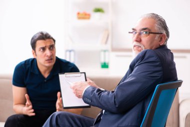 Genç adam yaşlı erkek psikoloğu ziyaret ediyor.