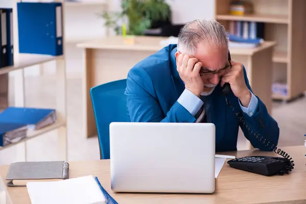 Velho contador masculino infeliz com excesso de trabalho no local de trabalho — Fotografia de Stock