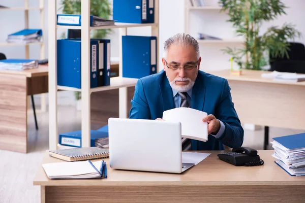 Velho contador masculino infeliz com excesso de trabalho no local de trabalho — Fotografia de Stock