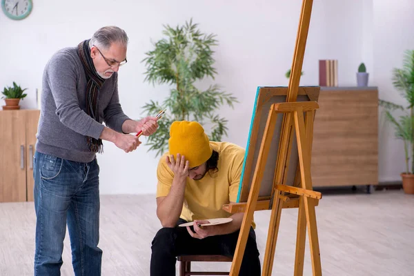 Joven tomando lecciones del viejo pintor — Foto de Stock