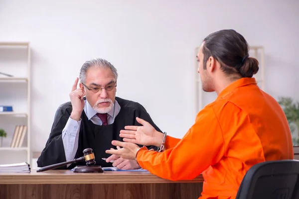 Velho juiz masculino reunião com jovem cativo no tribunal — Fotografia de Stock