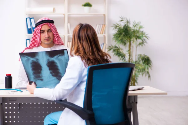 Joven árabe hombre de negocios visitando caucásico médico mujer —  Fotos de Stock