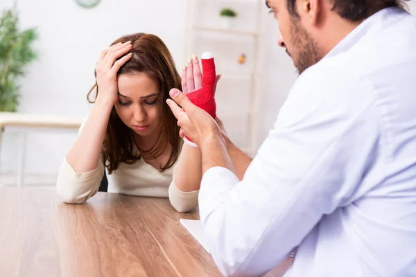 Ung hand skadad kvinna besöker manlig läkare traumatolog — Stockfoto