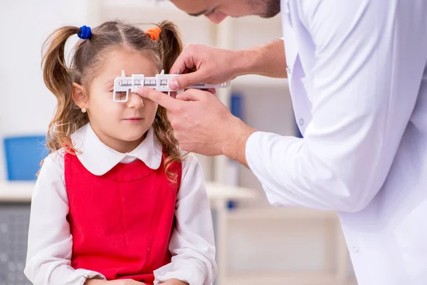 Klein meisje op bezoek bij jonge mannelijke arts oculist — Stockfoto