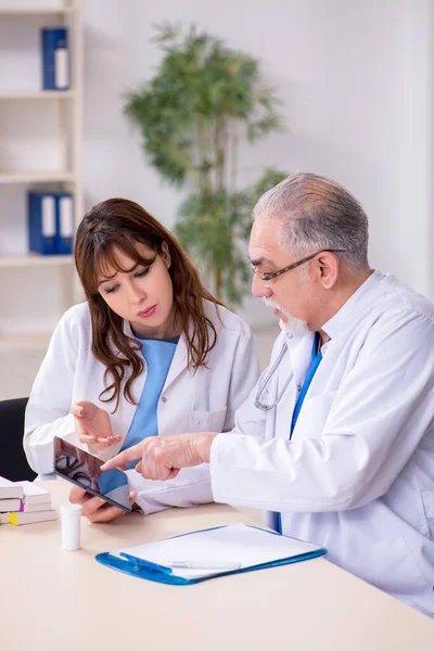 Yaşlı erkek doktor radyoloji uzmanı ve genç bayan asistanı. — Stok fotoğraf