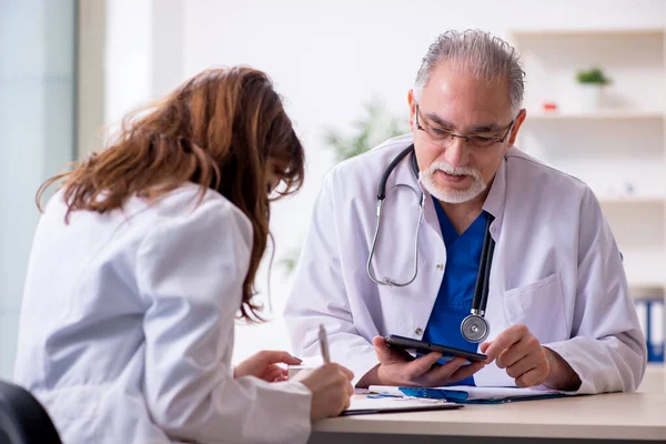 Yaşlı erkek doktor radyoloji uzmanı ve genç bayan asistanı. — Stok fotoğraf