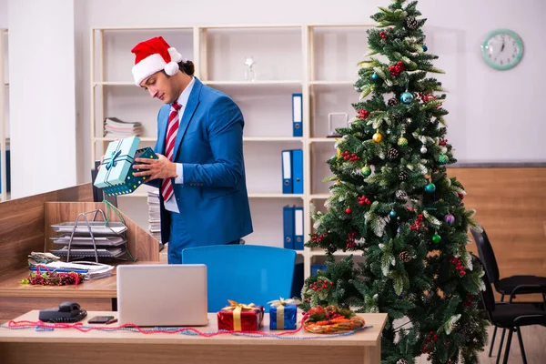 Mladý muž zaměstnanec slaví Vánoce na pracovišti — Stock fotografie