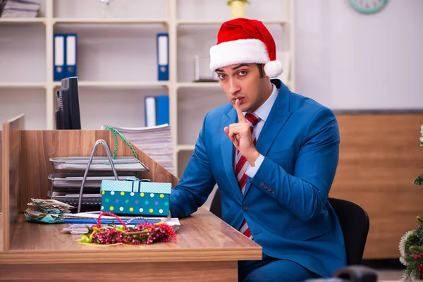 Mladý muž zaměstnanec slaví Vánoce na pracovišti — Stock fotografie