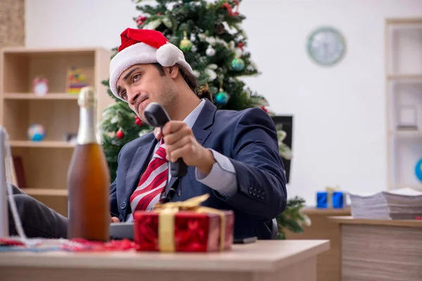 Молодой работник-мужчина празднует новый год в офисе — стоковое фото
