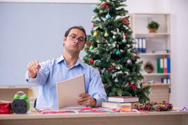 Genç erkek öğretmen okulda yeni yılı kutluyor.