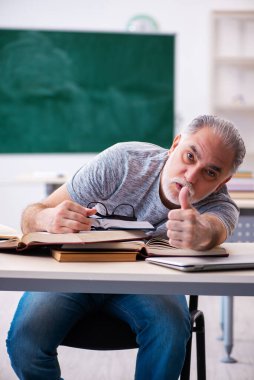 Sınav hazırlıkları sırasında yorgun düşen yaşlı bir erkek öğrenci.
