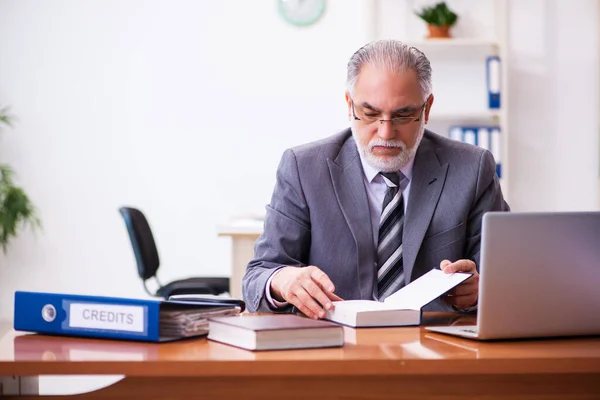 Starý obchodník zaměstnanec čtení směrnice v kanceláři — Stock fotografie