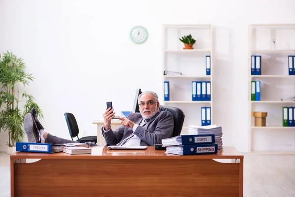 Старый работник-бизнесмен работает в офисе — стоковое фото