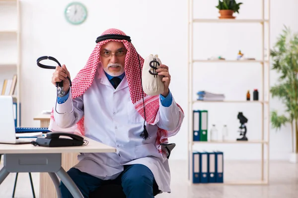Vieux médecin arabe homme tenant sac d'argent — Photo
