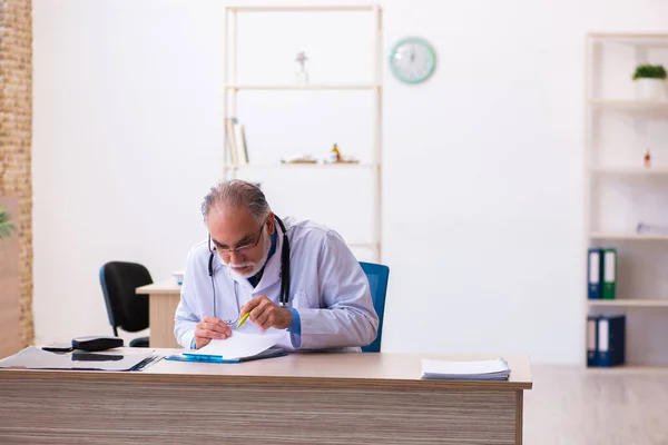 Starý lékař pracující na klinice — Stock fotografie