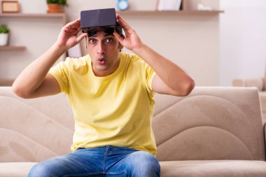 Evde sanal gözlüklü genç bir öğrenci.