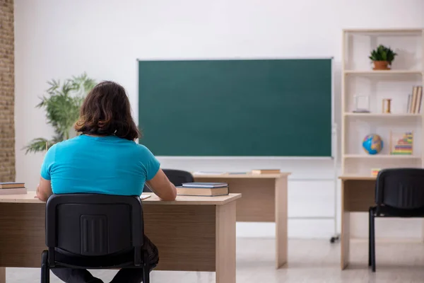 Jonge mannelijke student voor het groene bord — Stockfoto